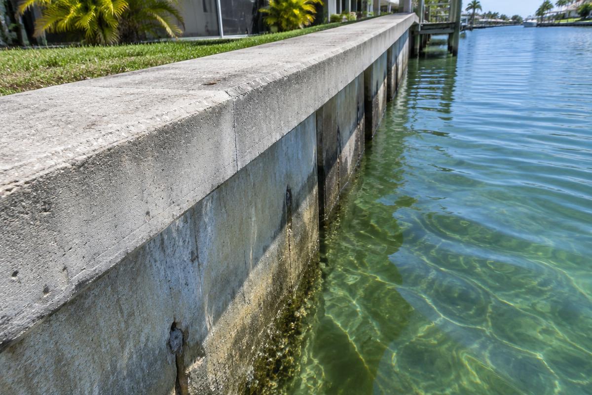 Concrete seawall and cap along a clear South Florida canal